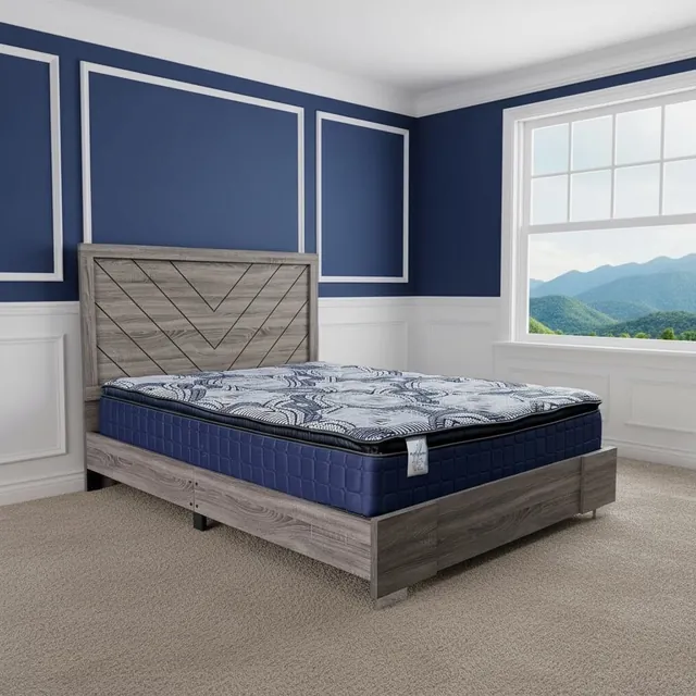 Pillow-top mattress with a blue patterned top and navy sides on a gray wood bed with a chevron headboard