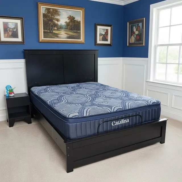 Catalina mattress with a blue patterned top and navy sides on a black wood bed beside a nightstand