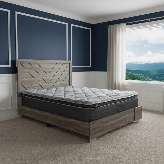 Mattress with a gray quilted top and dark sides on a gray wood bed with a chevron headboard